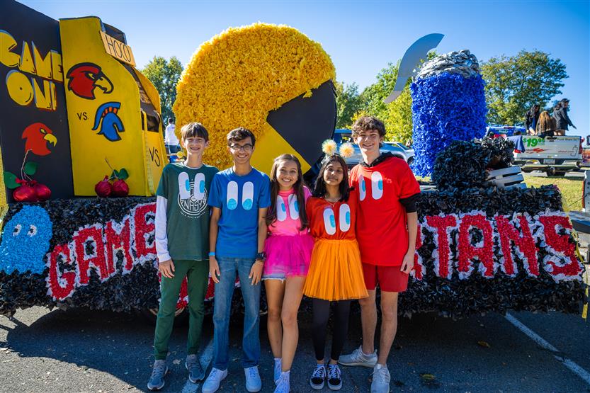 Students stand in front of a Pac-Man homecoming float